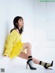 A woman in a yellow sweater and black and white checkered socks.