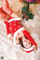 A woman in a red and white outfit laying in the snow.