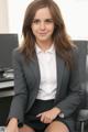 A woman in a business suit sitting at a desk.