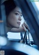 A woman sitting in a car looking out the window.