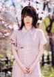 A woman standing in front of a flowering tree.